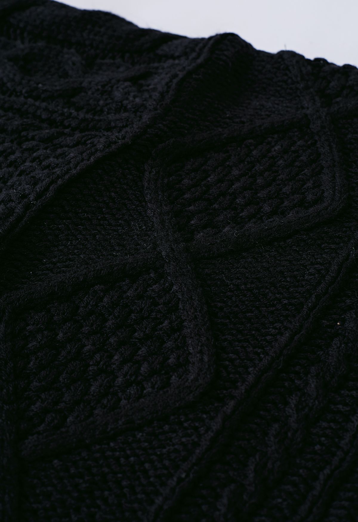 Suéter de punto de ochos con ribete de borlas y cuello alto en negro
