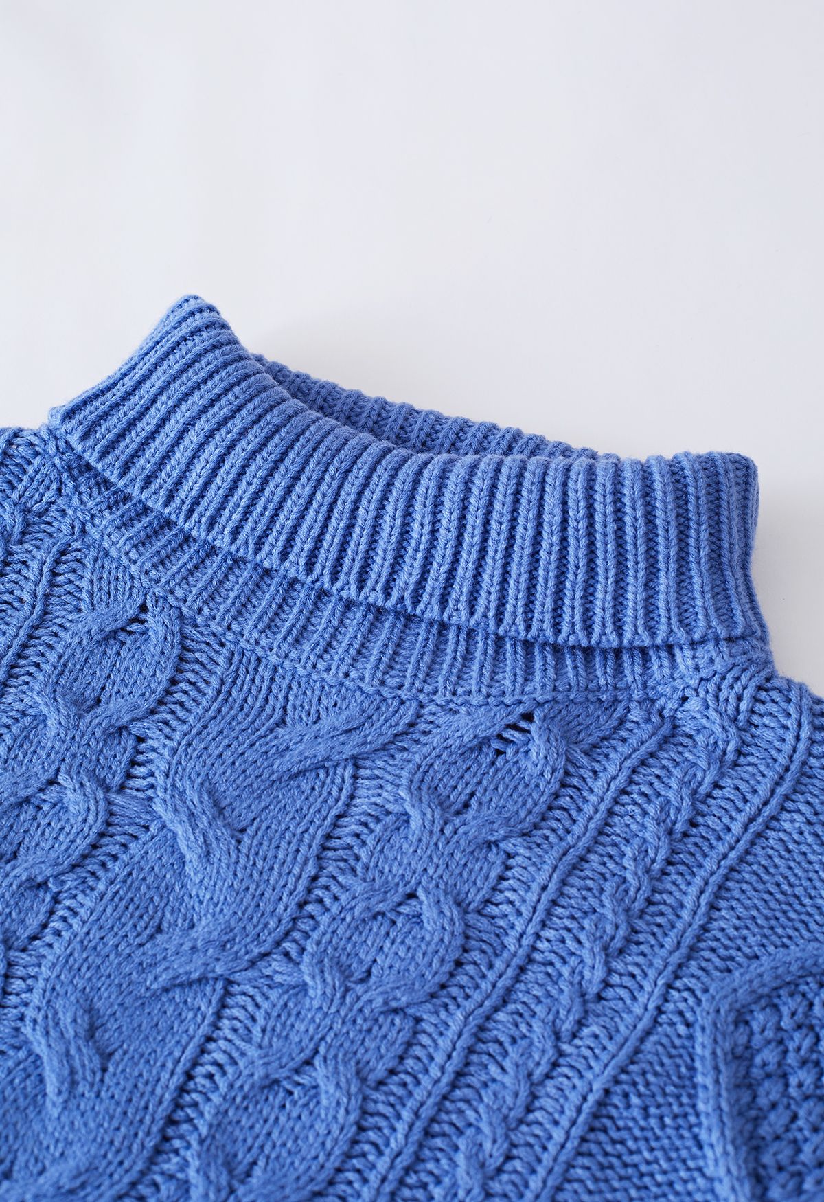 Suéter de punto de ochos con ribete de borlas y cuello alto en azul