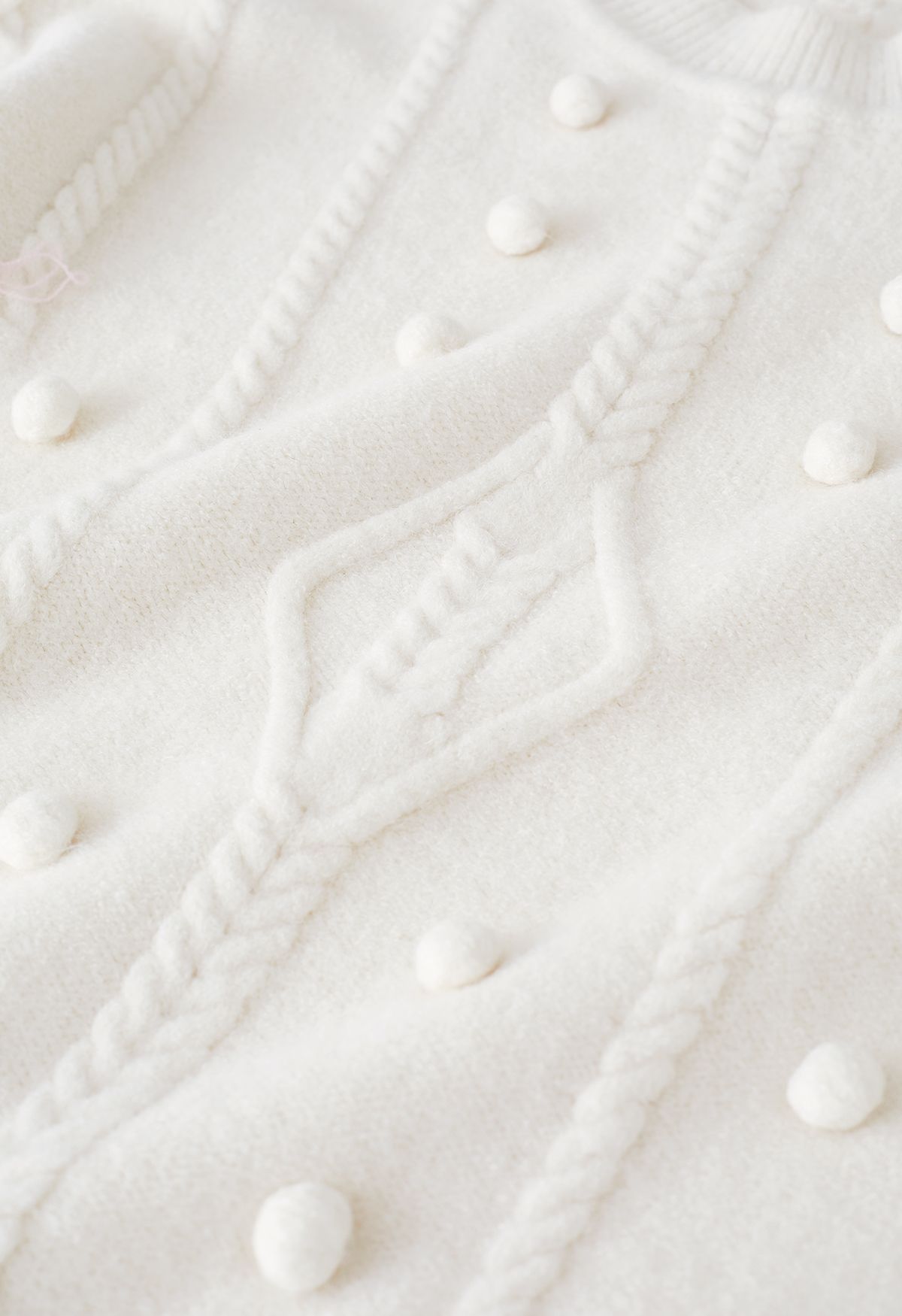 Suéter de punto trenzado con ribete de pompones en marfil