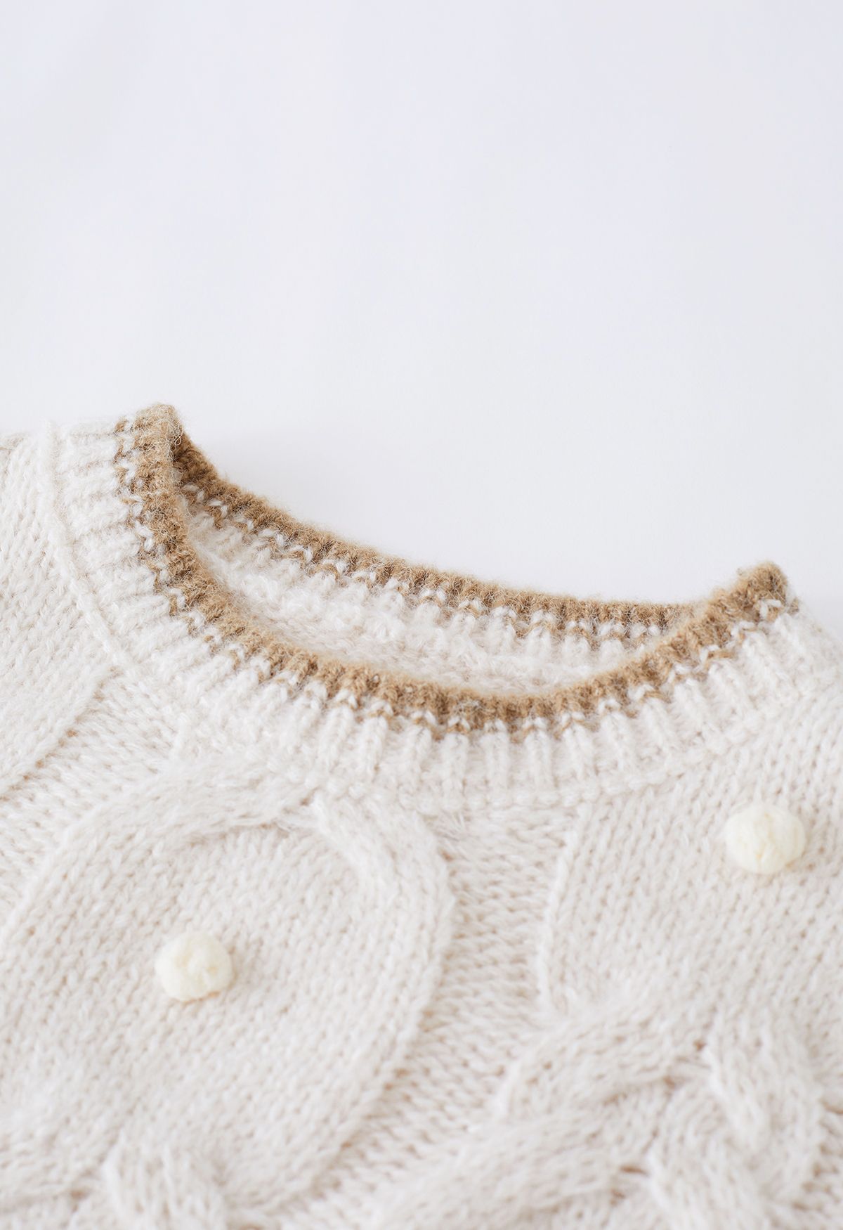 Suéter de punto trenzado con pompones y borde en contraste en marfil