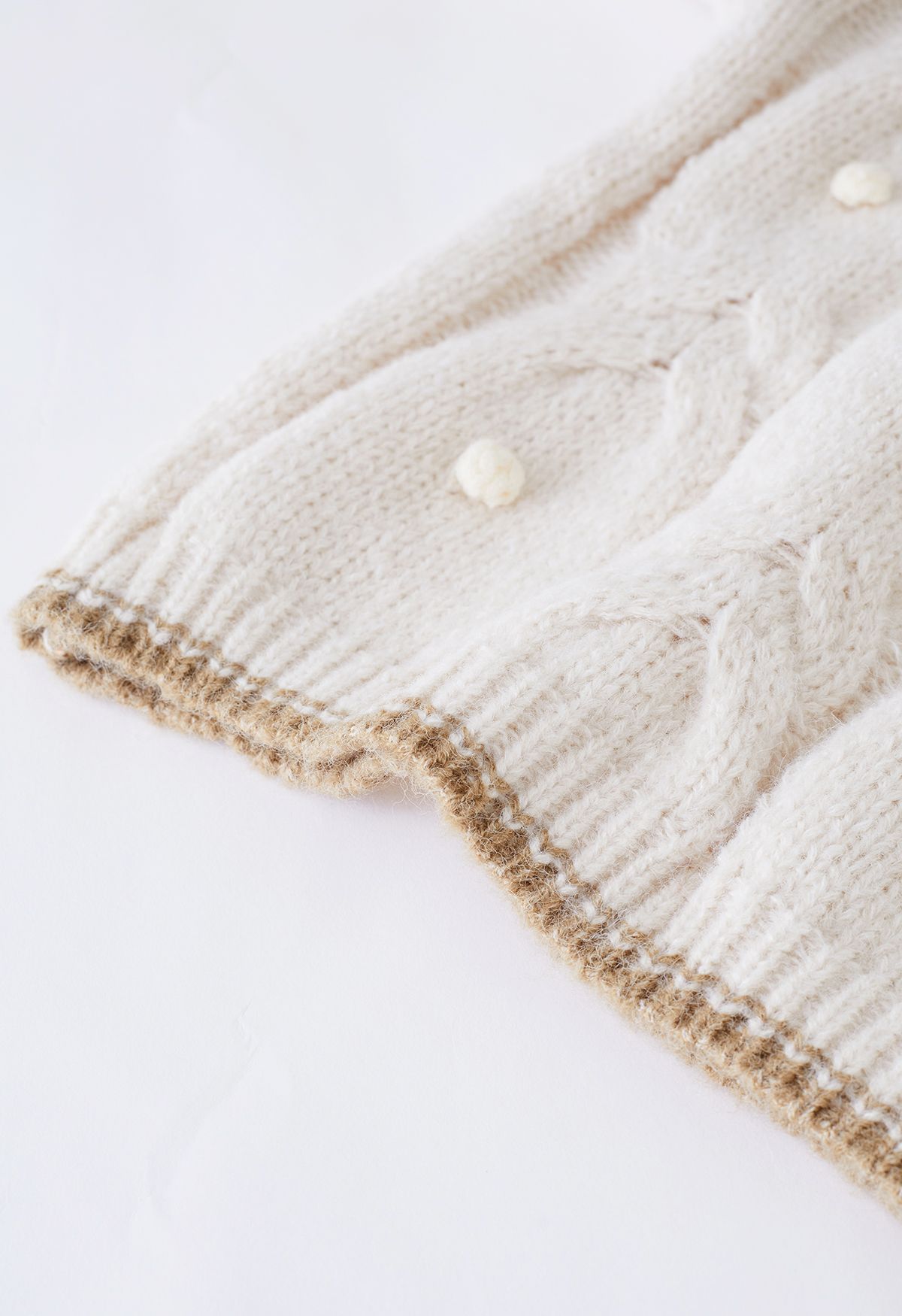 Suéter de punto trenzado con pompones y borde en contraste en marfil