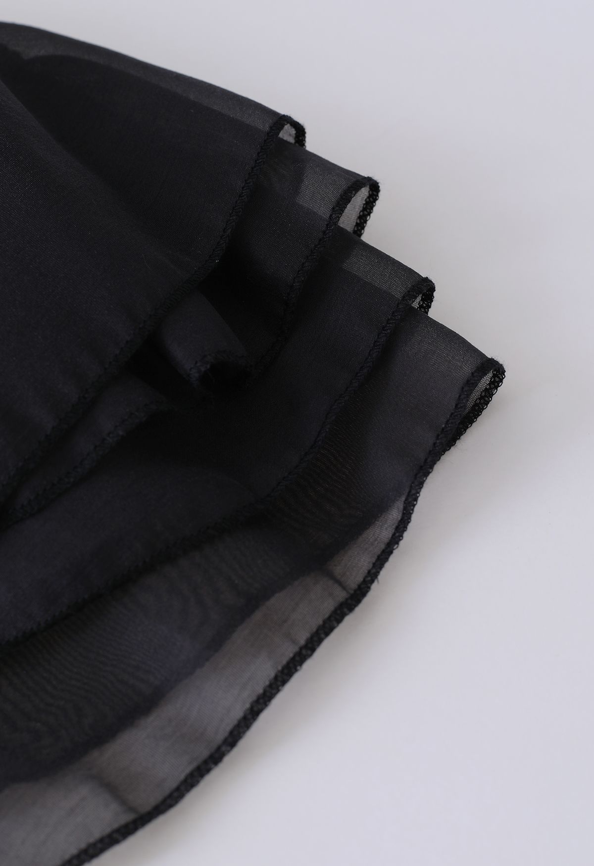 Top corto de punto con mangas onduladas escalonadas empalmadas en negro